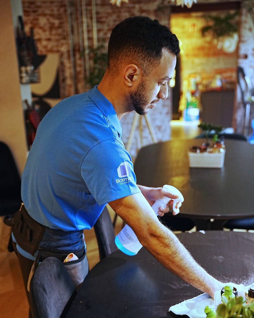 Medewerker van Bickmann Schoonmaak reinigt een tafel